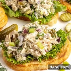 Dill pickle chicken salad on toast, garnished with fresh dill.