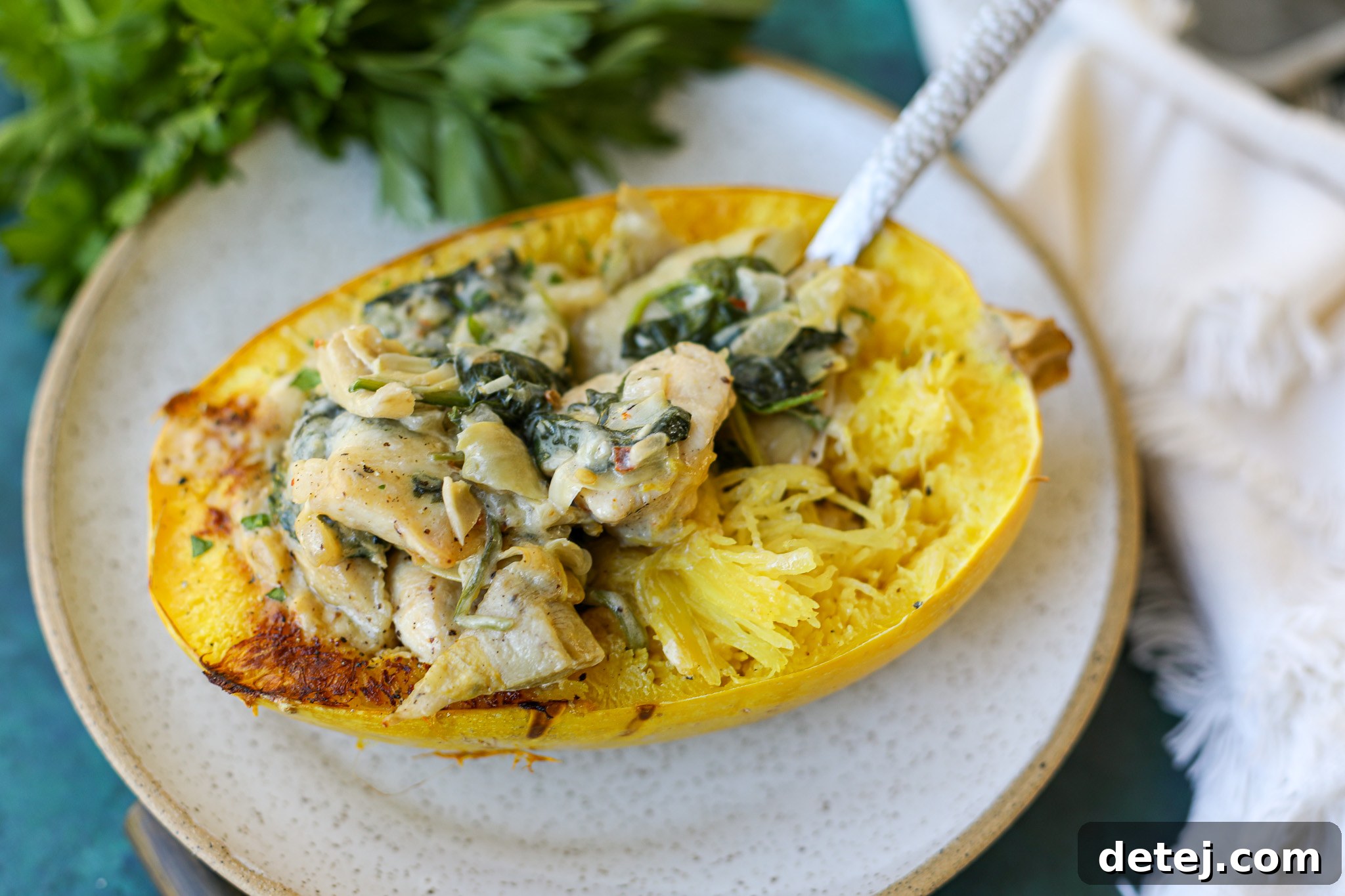 The finished Creamy Chicken Spinach Artichoke Stuffed Spaghetti Squash, baked to perfection with melted cheese on top.