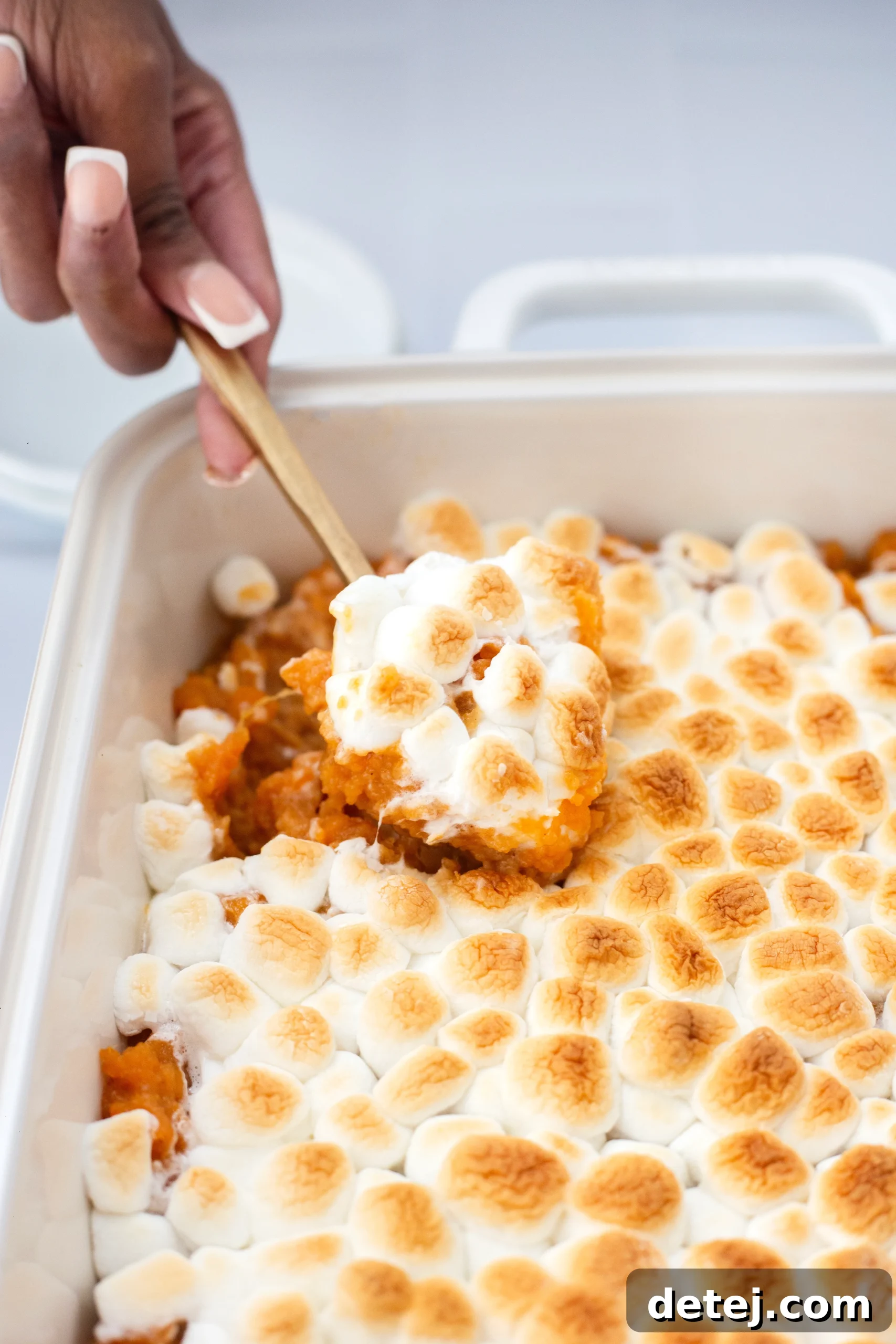 Close-up of a portion of sweet potato casserole, highlighting the creamy texture and marshmallow topping.