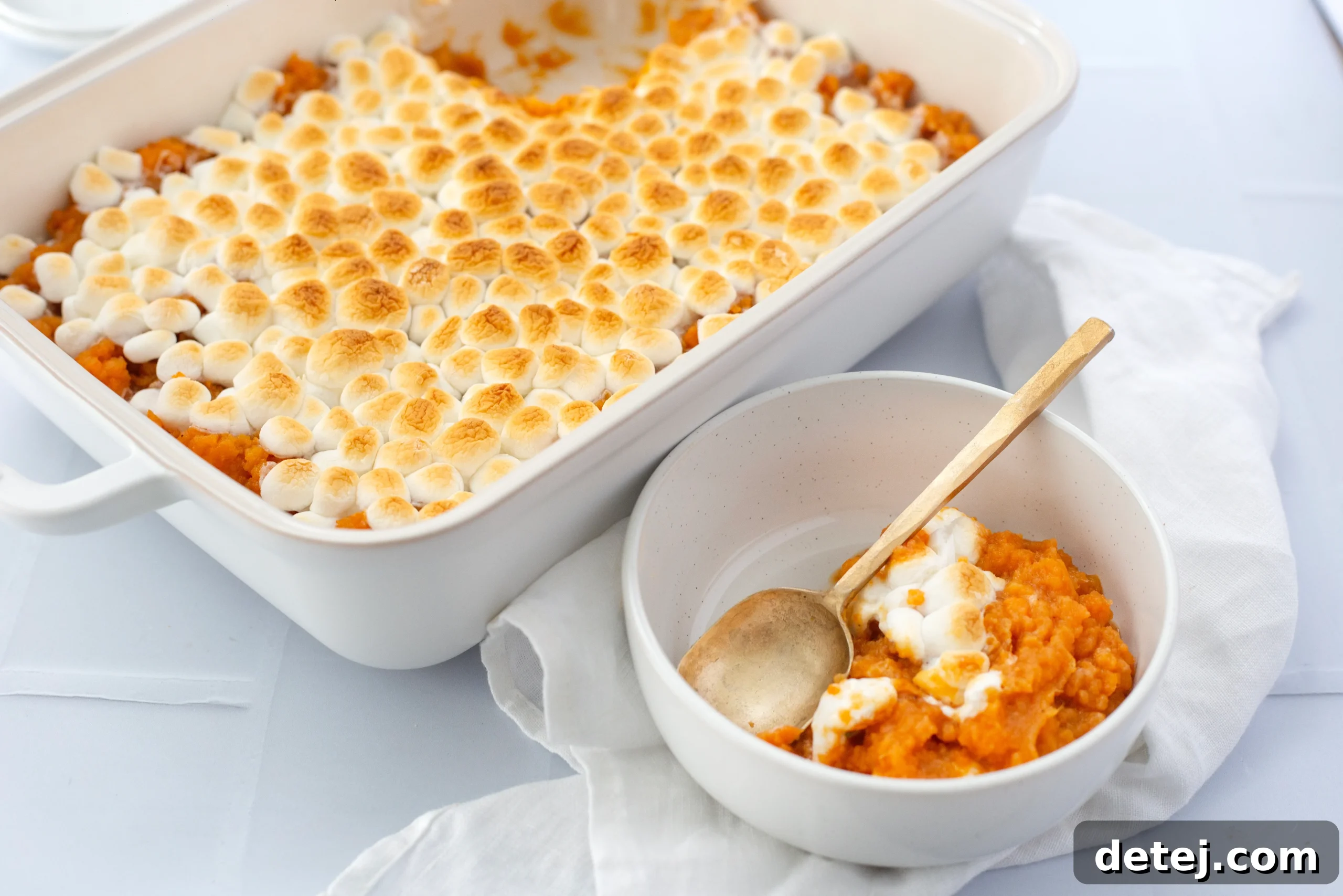 A full sweet potato casserole dish on a wooden table, ready to be served.