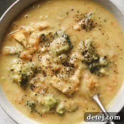 A vibrant bowl of healthy chicken broccoli cheddar soup, garnished with fresh greens, ready to be enjoyed.