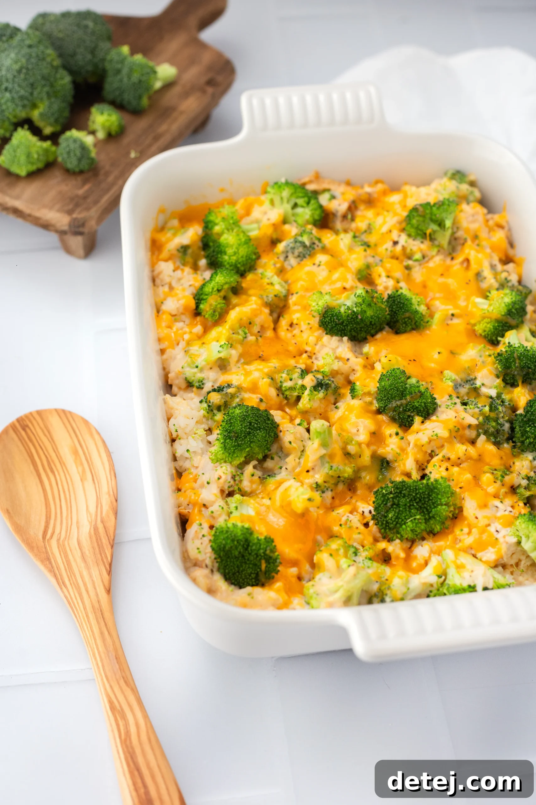 A close-up shot of a golden-brown cheesy chicken broccoli rice casserole, freshly baked and bubbling in a baking dish.