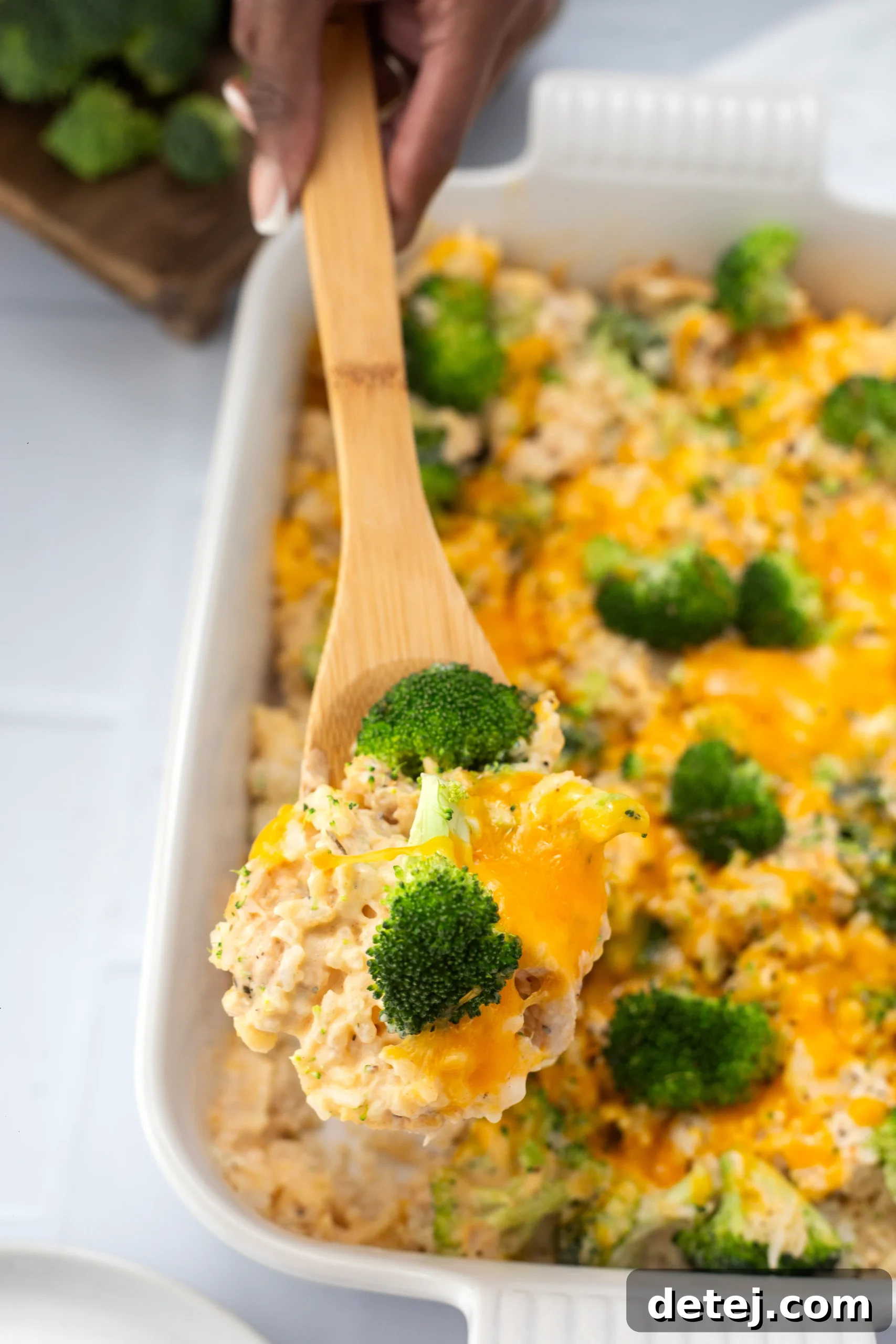 A top-down view of a large serving of cheesy chicken broccoli rice casserole, hot and ready to eat.