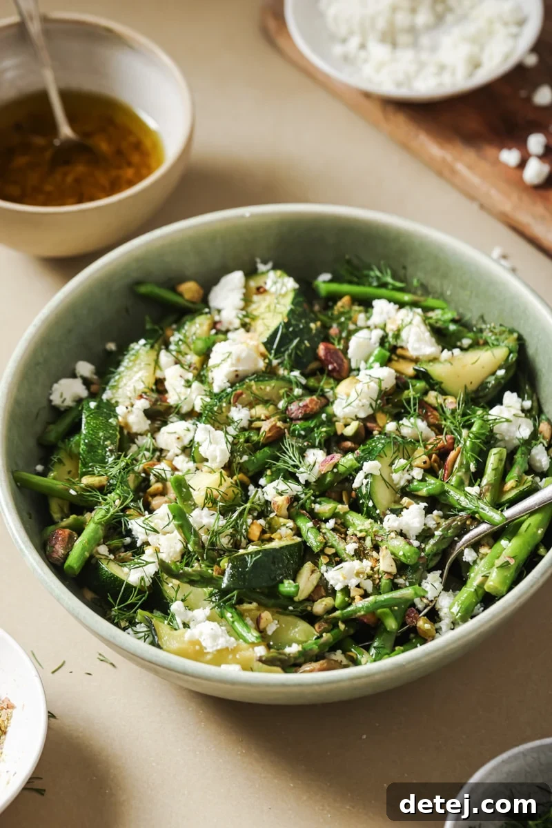 A close-up side view of the beautifully assembled Sautéed Spring Vegetable Salad, garnished with fresh herbs and ready to be enjoyed.