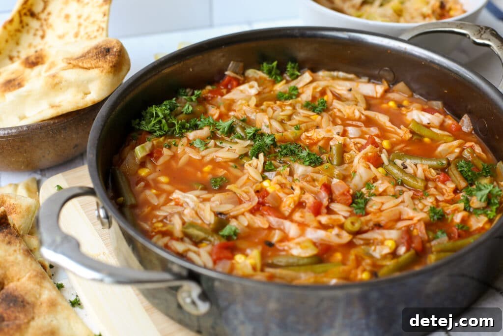 Savory Cabbage Soup with Tender Orzo 2 A vibrant, steaming bowl of Cabbage Soup with Orzo Pasta, garnished with fresh herbs, showcasing the tender vegetables and small pasta. The soup sits on a rustic wooden surface, inviting you to enjoy its warmth and healthy goodness.