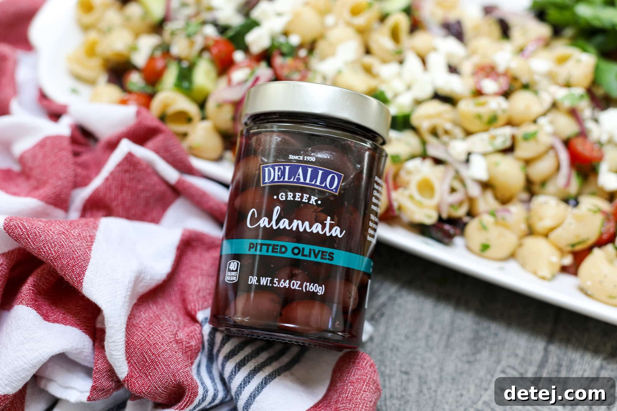 Close-up shot of plump Delallo Calamata olives, showcasing their rich color and texture, ready for the Greek pasta salad.