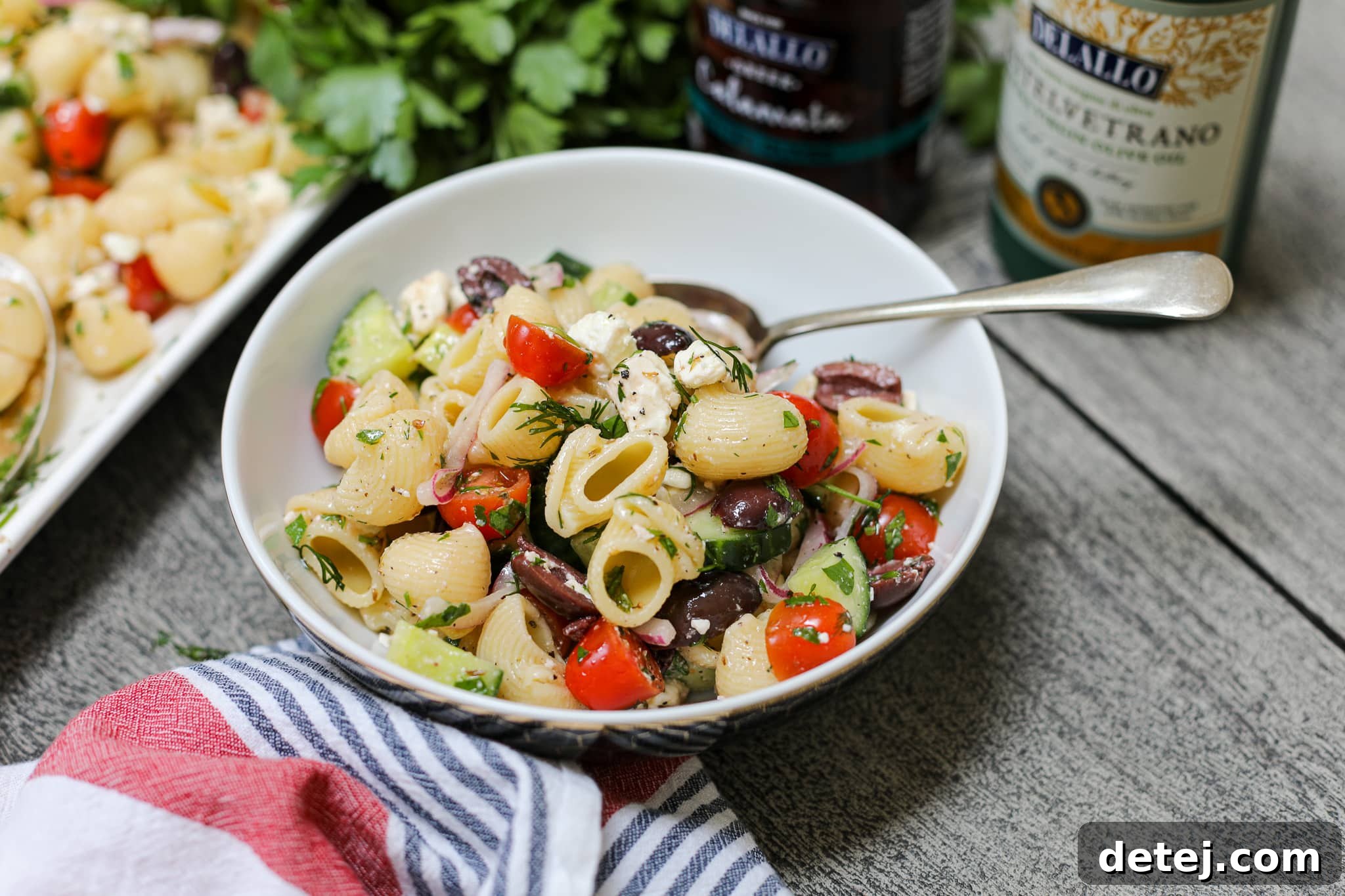 Close-up of a bowl filled with colorful and fresh Greek Pasta Salad, showcasing the delicious combination of pasta, vegetables, feta, and olives.