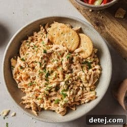 buffalo chicken salad in a bowl with cracker on the side.