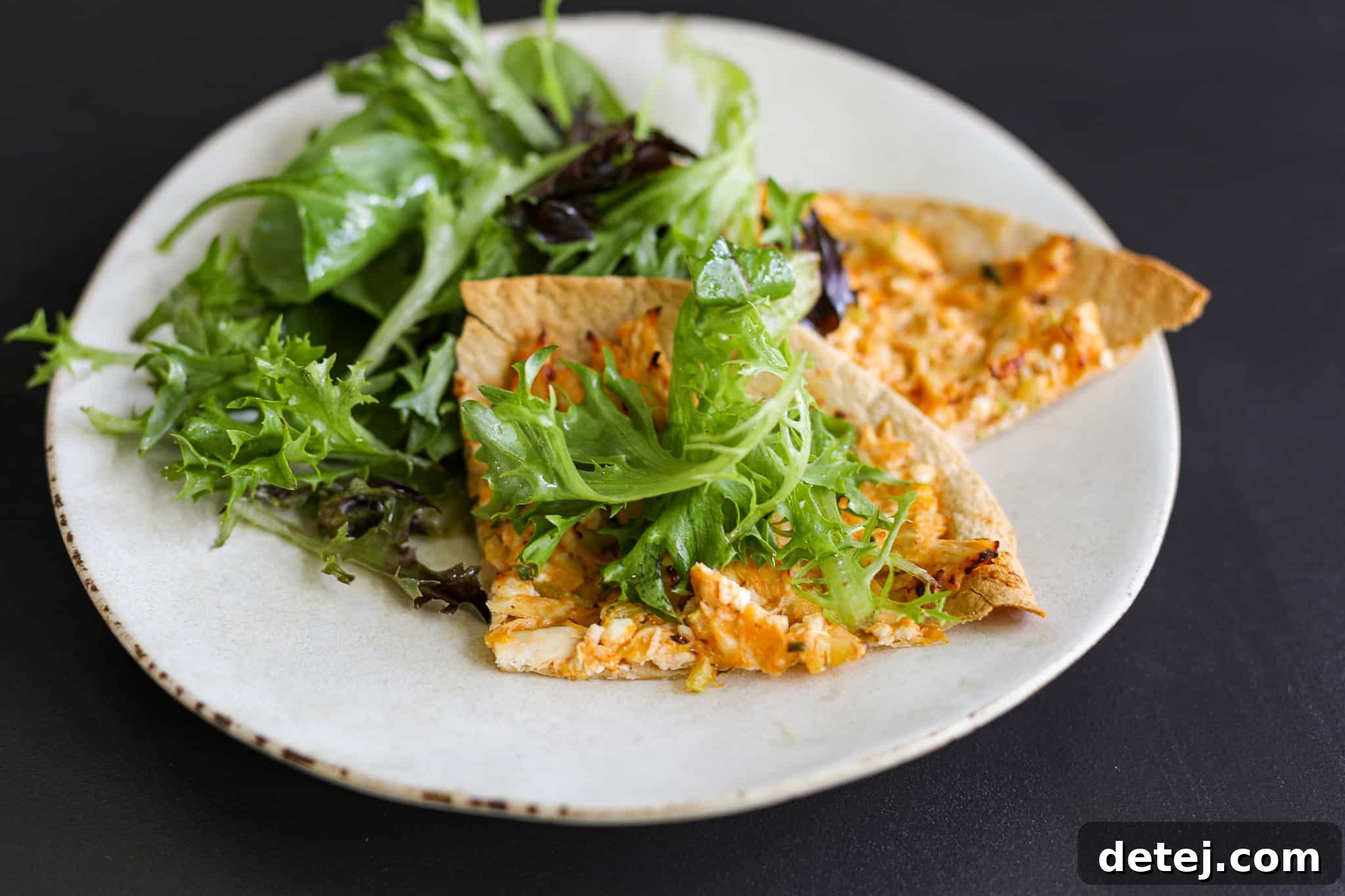 Leftover buffalo chicken salad transformed into a personal pizza on a tortilla, highlighting its versatility.