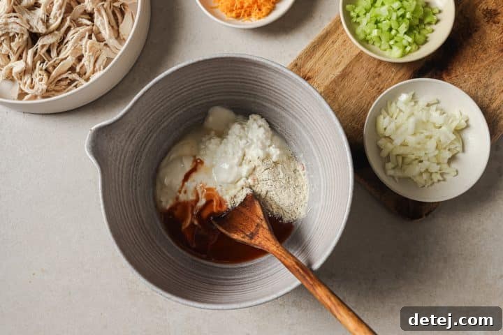 Separate bowls of cottage cheese, Greek yogurt, buffalo sauce, lemon juice, and ranch seasoning, ready to be combined for the dressing.