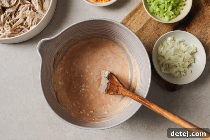 The buffalo dressing ingredients are thoroughly mixed in a bowl, creating a smooth and vibrant base for the chicken salad.