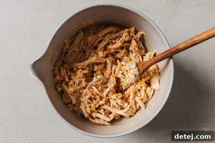 The chicken and dressing are mixed together until all ingredients are well combined and coated.