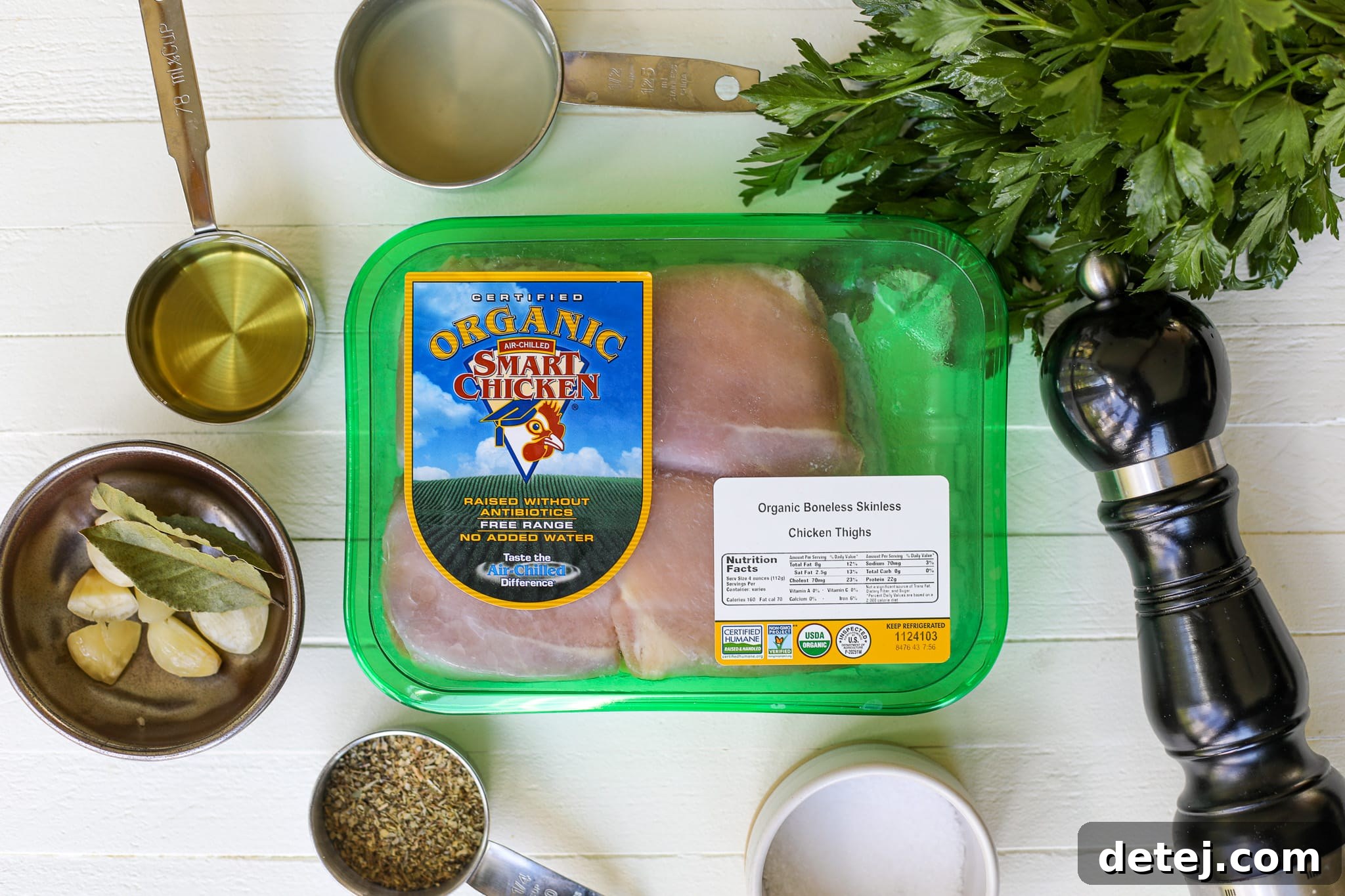 Fresh ingredients laid out for Greek chicken souvlaki, including chicken, lemon, and herbs.