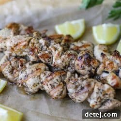 Finished grilled chicken souvlaki skewers, garnished with fresh parsley.
