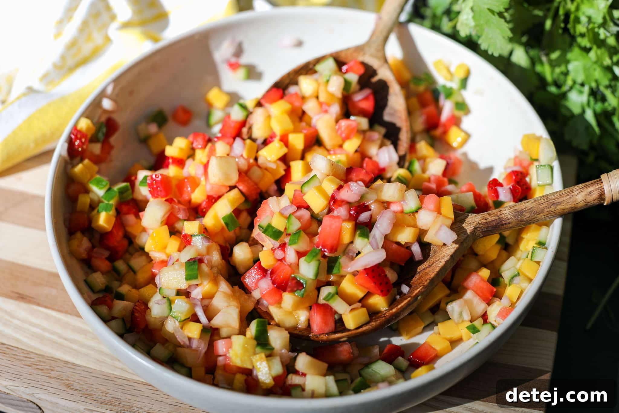 Scoop of fresh fruit salsa being lifted on a chip, showcasing the vibrant colors and appealing texture, ready for a taste.