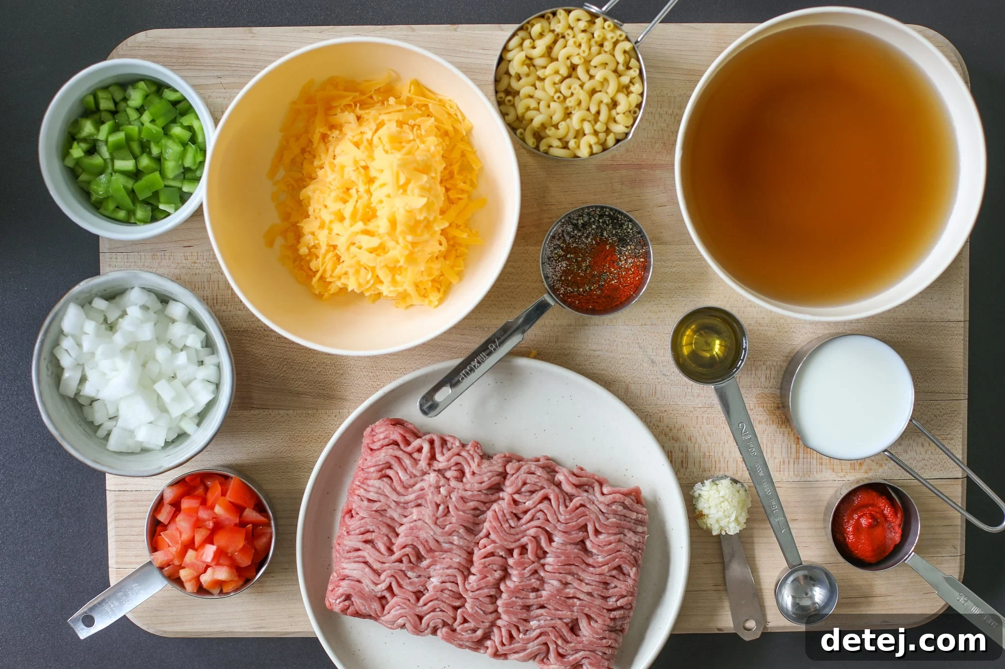 Fresh ingredients laid out for making One Pot Homemade Hamburger Helper, including ground beef, vegetables, and spices