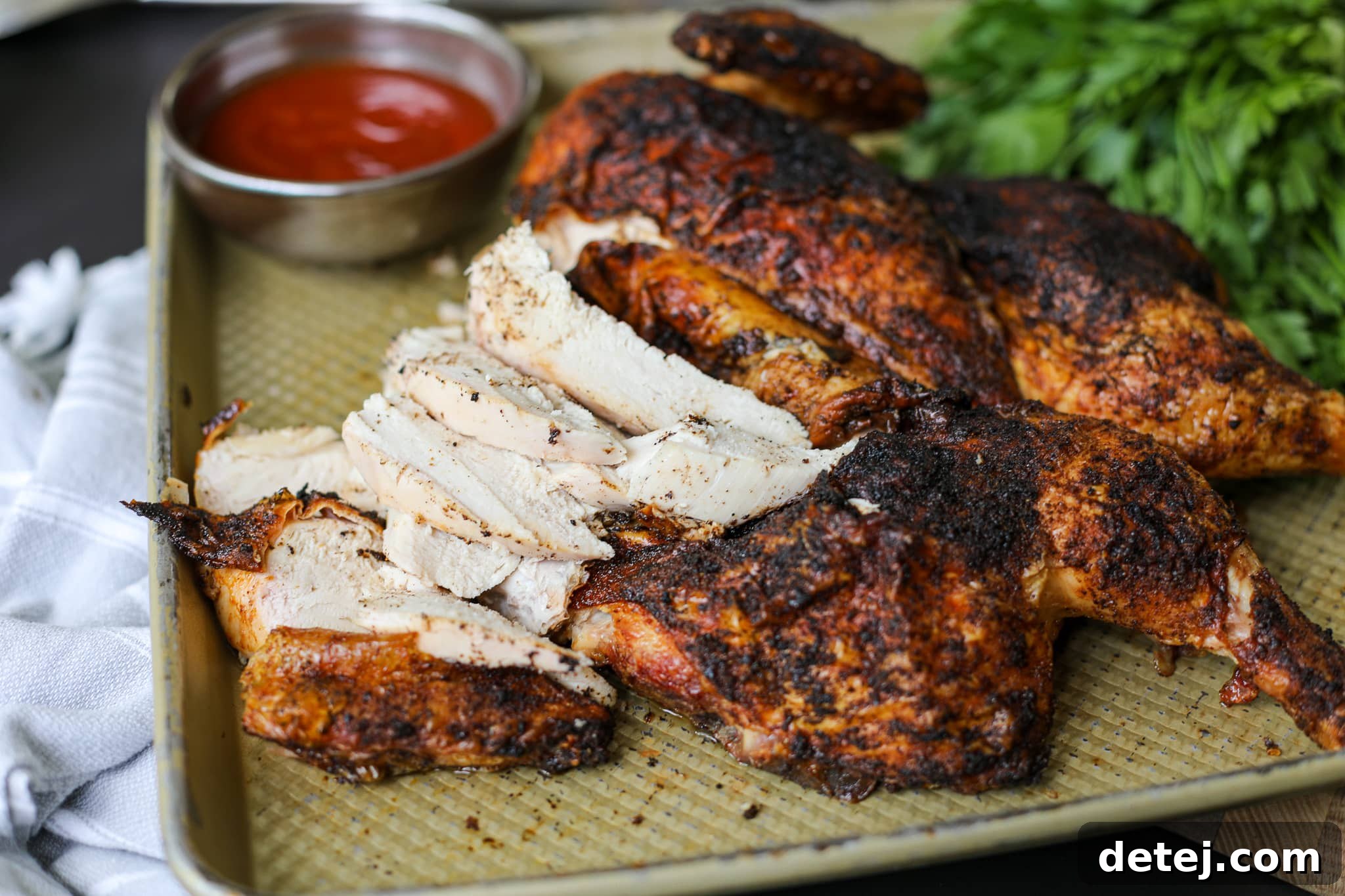 Perfectly sliced juicy grilled whole chicken, showing tender meat and crispy skin.