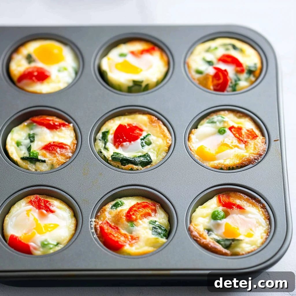 Freshly baked egg white and vegetable cups cooling in a muffin tin, golden brown and ready to eat