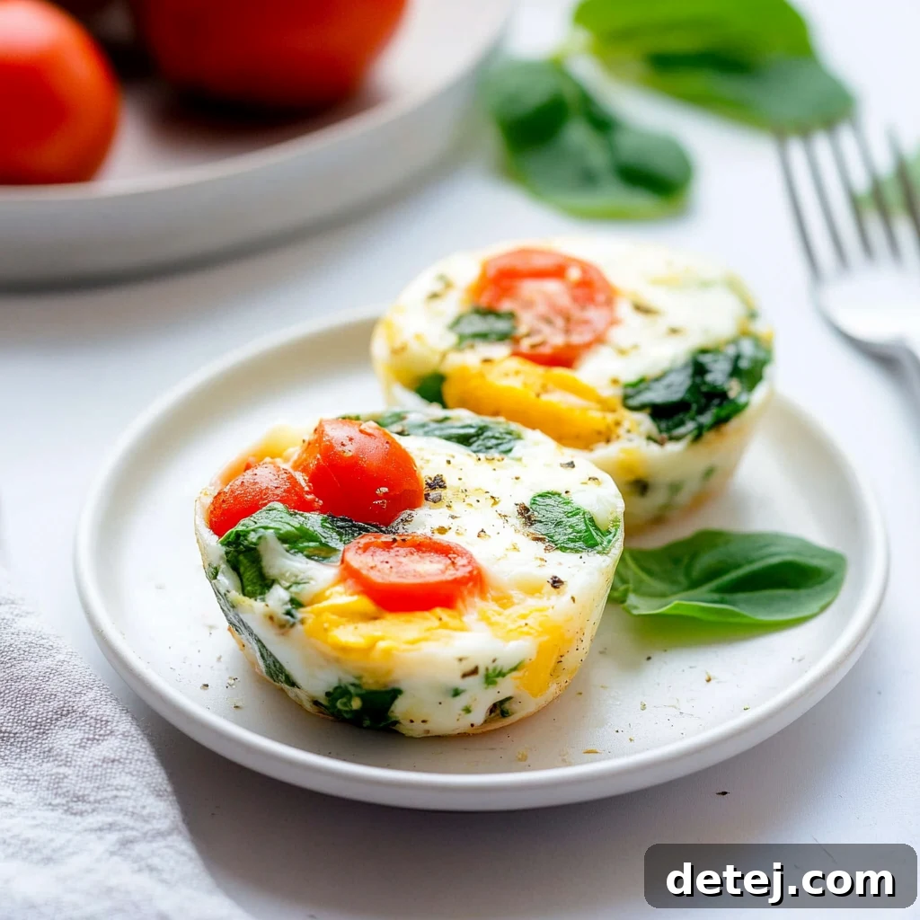 A close-up shot of a single baked egg white and vegetable cup, showcasing its texture and ingredients
