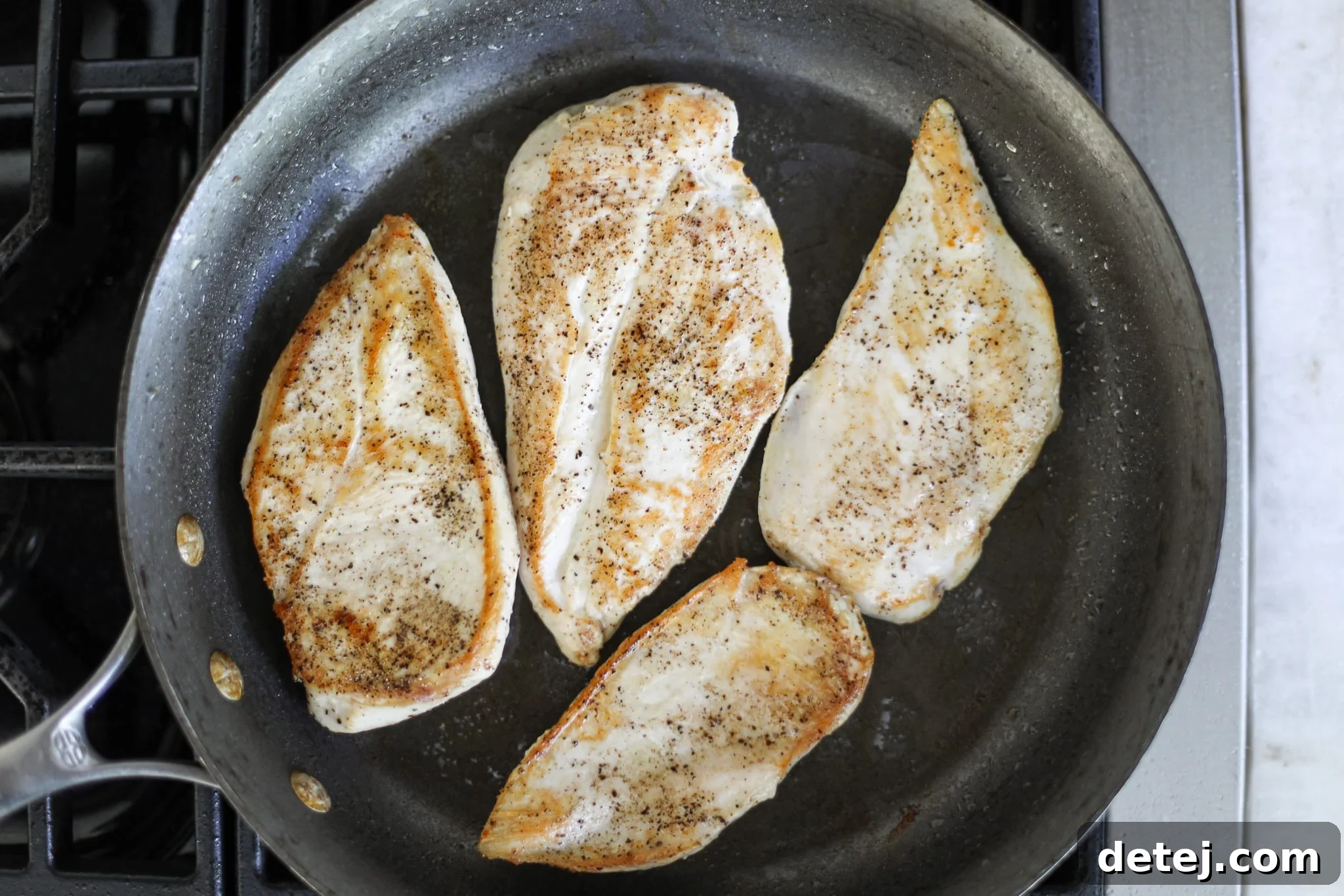 pan seared chicken breasts in a hot skillet. 