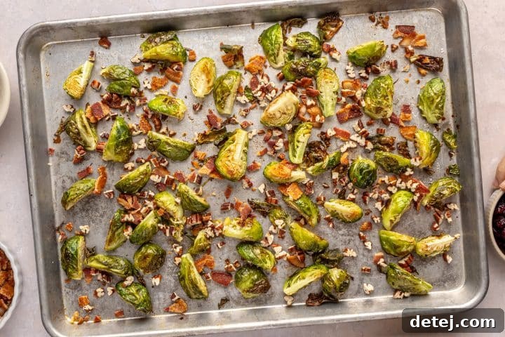 Dried cranberries added to the baking tray with Brussels sprouts and bacon.