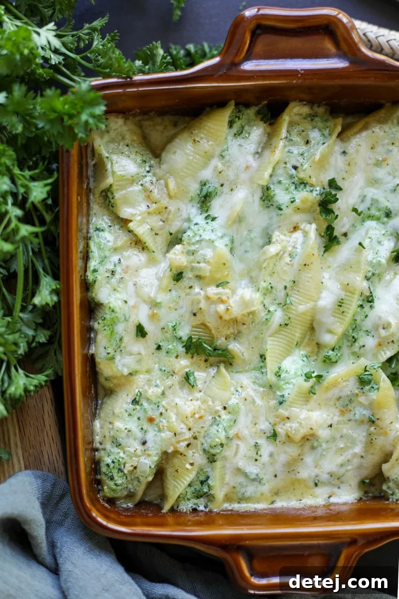 cheesy stuffed shells fresh from the oven, garnished with fresh herbs.