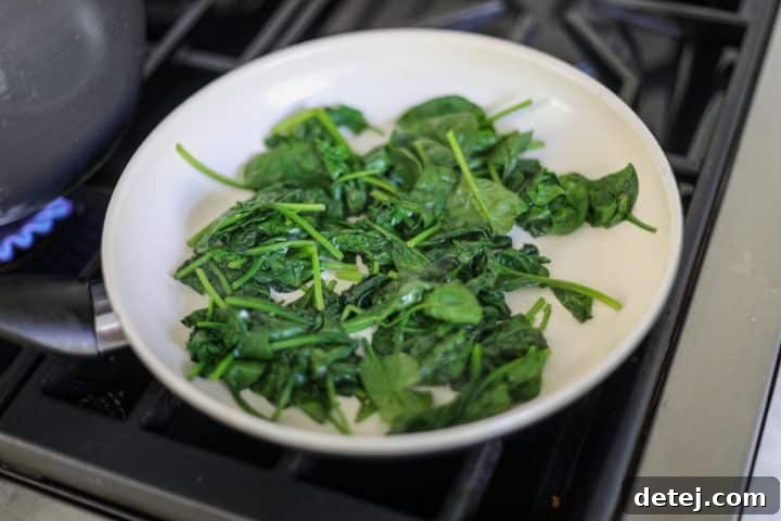 cooked and wilted spinach in a pan, reduced in volume.