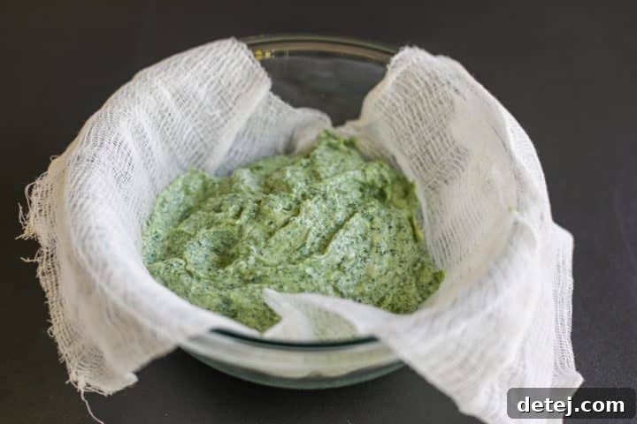 cheese filling in a cheesecloth, being squeezed to remove excess moisture.