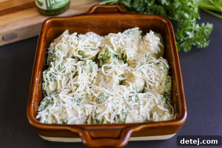 stuffed shells in a baking dish with shredded cheese generously sprinkled on top.