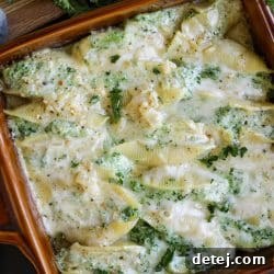 overhead image of cheesy stuffed shells with pesto sauce, ready to serve.