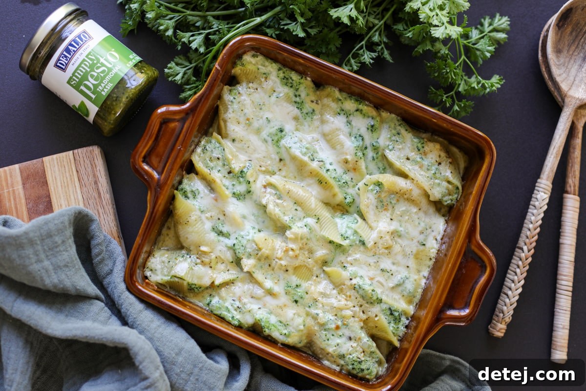 pesto and whipped ricotta stuffed shells fresh from the oven, showing golden-brown cheese.