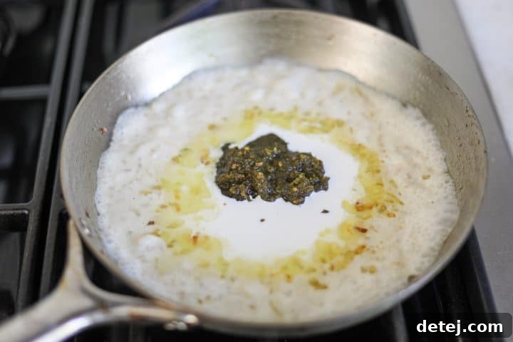 creamy pesto sauce simmering in a pan, ingredients combined.
