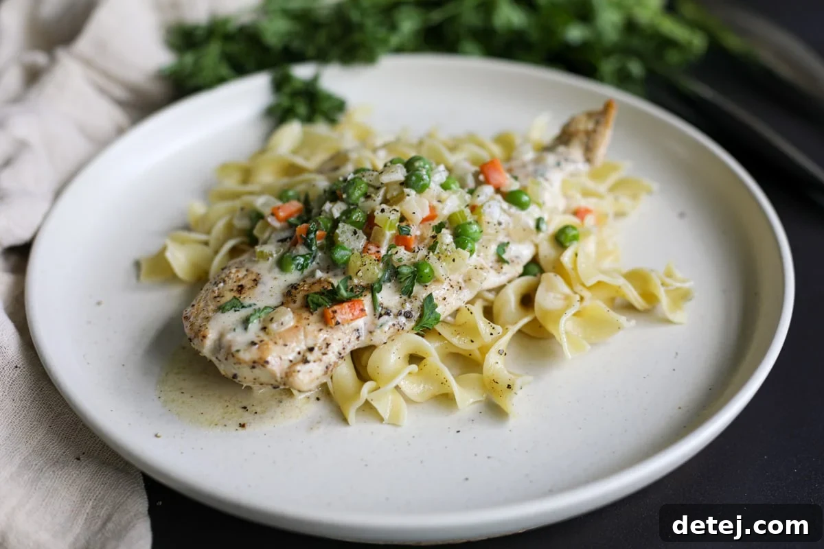 Creamy Chicken and Vegetables served over egg noodles in a bowl.