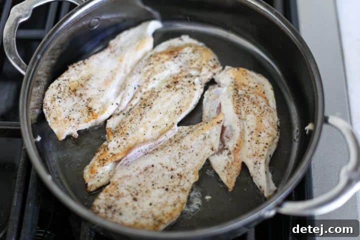 Golden-brown cooked chicken cutlets in a pan, ready to be removed.