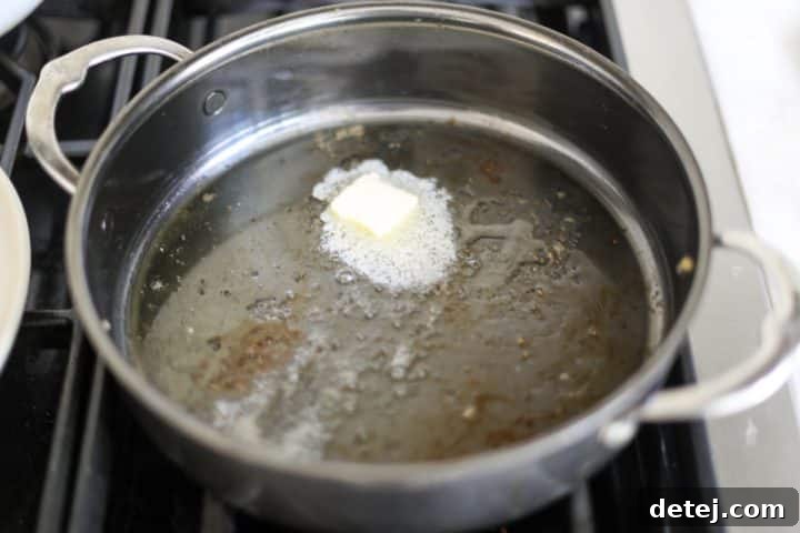 Butter melting and sizzling in the hot pan, preparing for vegetables.