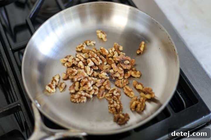Walnuts toasting in a non-stick pan.
