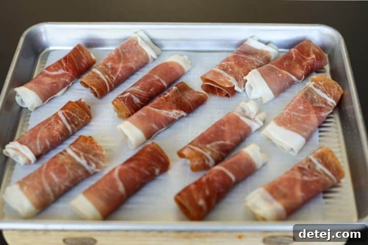 Multiple prosciutto rolls, neatly prepared with Boursin cheese.