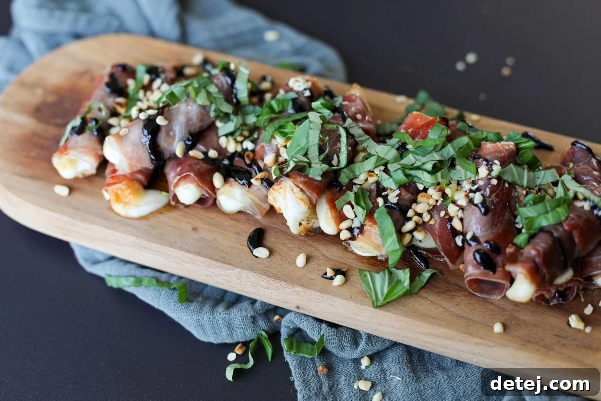 A close-up shot of Crispy Prosciutto and Mozzarella Roll-Ups on a wooden serving board, showcasing the melted cheese and fresh garnishes.