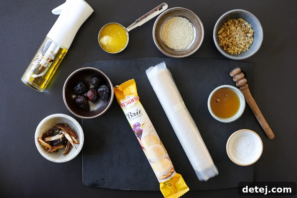 Ingredients for Crispy Phyllo Wrapped Brie Roll-Ups, including phyllo dough, brie, dates, and olive oil