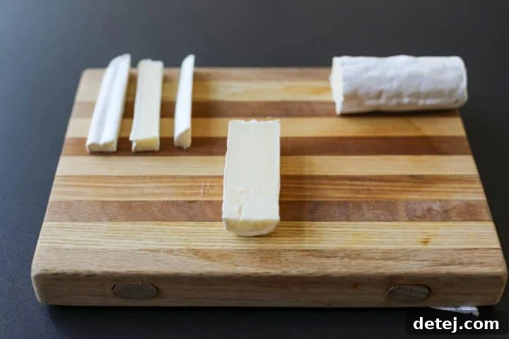 Brie log being carefully sliced into uniform halves for even portions