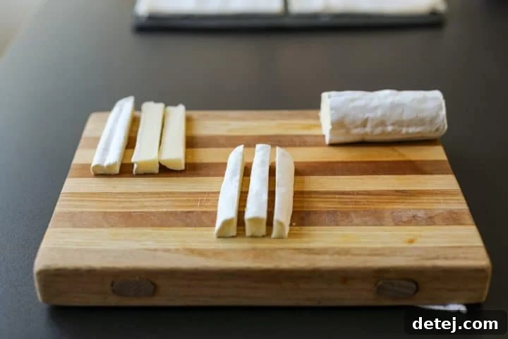Brie log quartered and then further divided into long, thin sticks for easy rolling