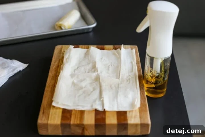 Three layers of phyllo dough arranged on a cutting board, ready for the next step