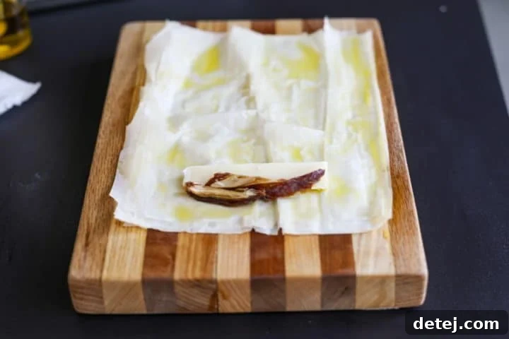 Phyllo dough with a brie stick and thin date slices placed ready for wrapping