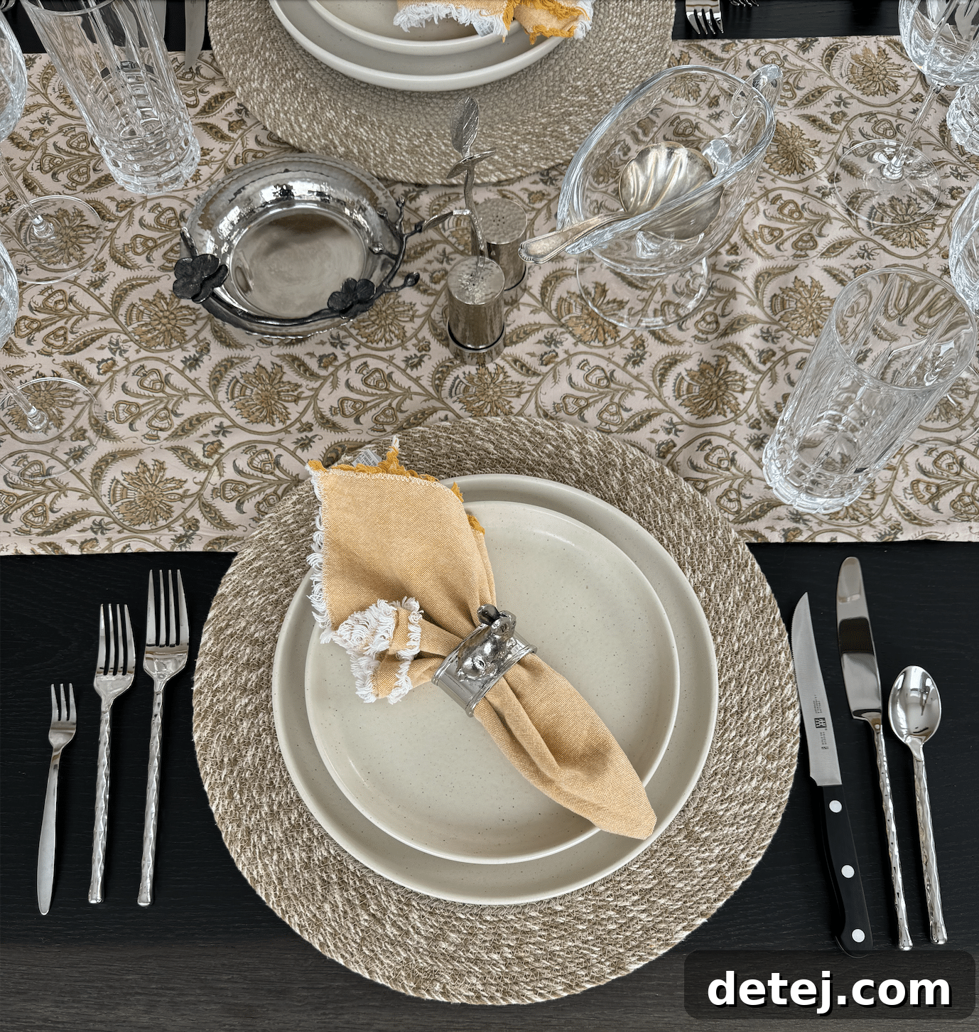 A beautifully set Thanksgiving table with fine china, crystal glasses, and autumn decor.