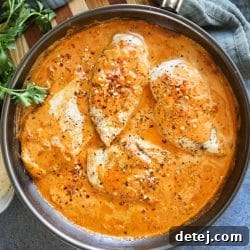 Beautifully presented Creamy Sun-Dried Tomato Pesto Chicken, garnished with fresh herbs, ready to be served.