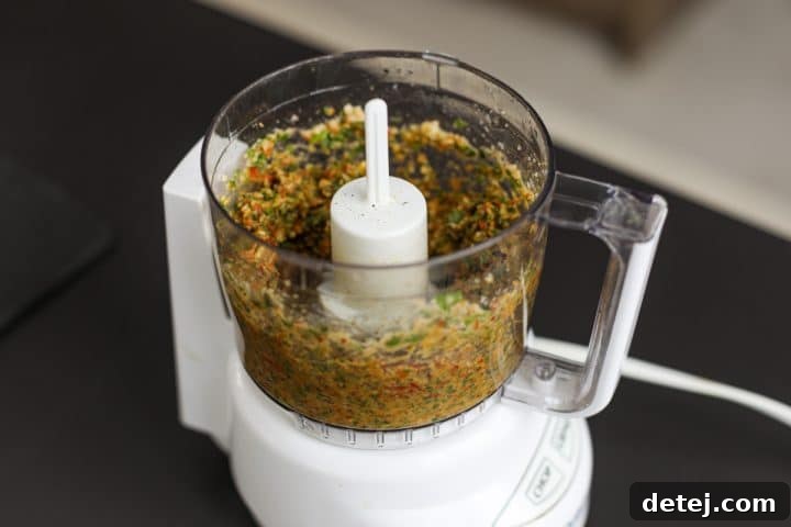 Partially blended sun-dried tomato pesto showing a textured, not completely smooth, consistency.