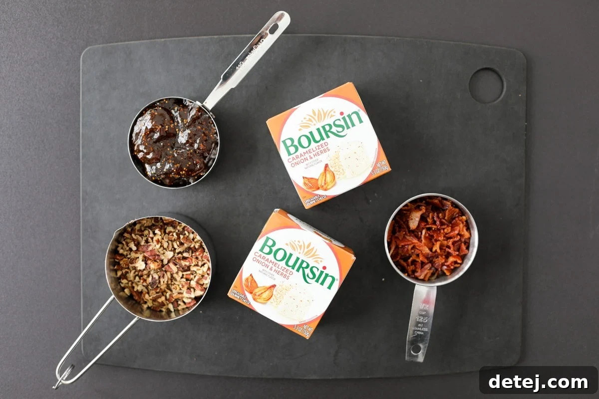 A close-up of the four essential ingredients for the Boursin cheese fig dip: blocks of Boursin cheese, a jar of fig jam, crispy bacon bits, and toasted pecans.