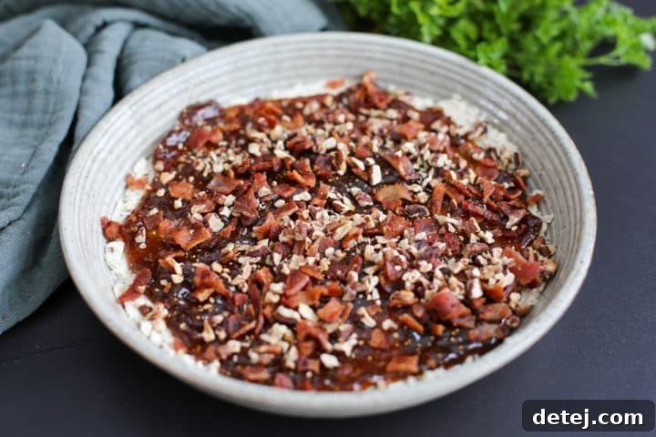 The Boursin fig dip fully assembled, generously topped with crispy chopped bacon and toasted chopped pecans.