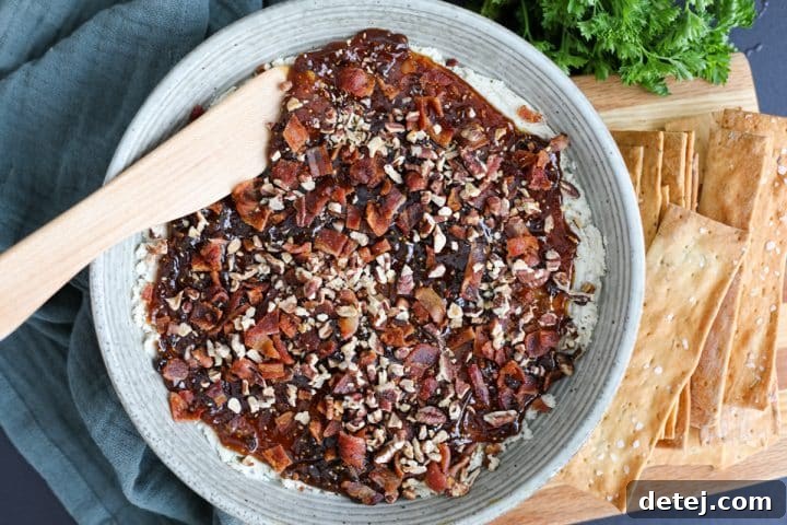 The finished Boursin fig dip presented in a bowl, ready to be served with a side of crackers.