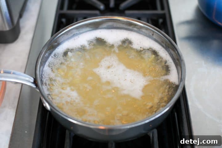 Orzo pasta boiling in a pot of water on the stove.